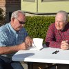 Local authors Bill Black (left) and Stephen Emanuels sign their book, "A Lonesome Place to Live" at the Sarah Mooney Museum on Sunday.