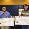 National Rifle Association representative Paul Rodarmel presents checks to Richard Lehn of the Lemoore Hot Shots, a local group that fires pellet guns at an indoor range at the Lemoore Rec Center.