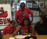 Lemoore High's Alyssa Vasquez signs her letter of intent flanked by parents and family.