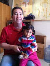 Kings Lions Club member Jeff Garcia helps a small child in Ensenada