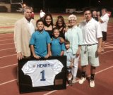 Longtime All Star Football chairman Bill Henry's family accepts jersey honoring him for his service.