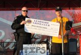 Sergeant Jim Chaney accepts a $1,000 check from Lemoore Lions on behalf of the Police Activities League.