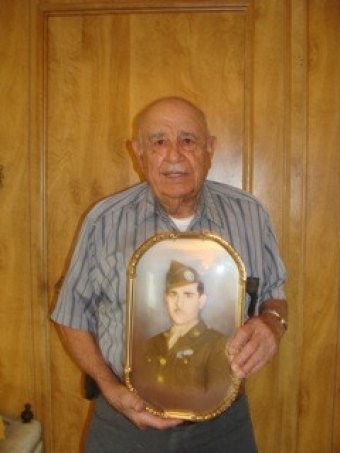 Julian Mazuka, 92, a veteran of World War II, holds a photo of himself in uniform from 1944.