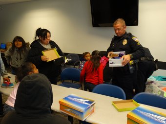 Officer Kevin Cosper helps out at the Lemoore Police Shoe Drive Monday afternoon.