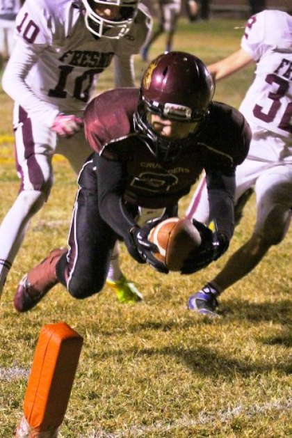 Kings Christian's Eric Savage lunges for yardage against Fresno Christian