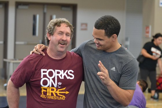 Kent Olson, left, shares a moment with former Tiger state wrestling champ and college national champion Chris Pendleton during a local basketball camp. Olson is the new head coach at Dinuba High School.