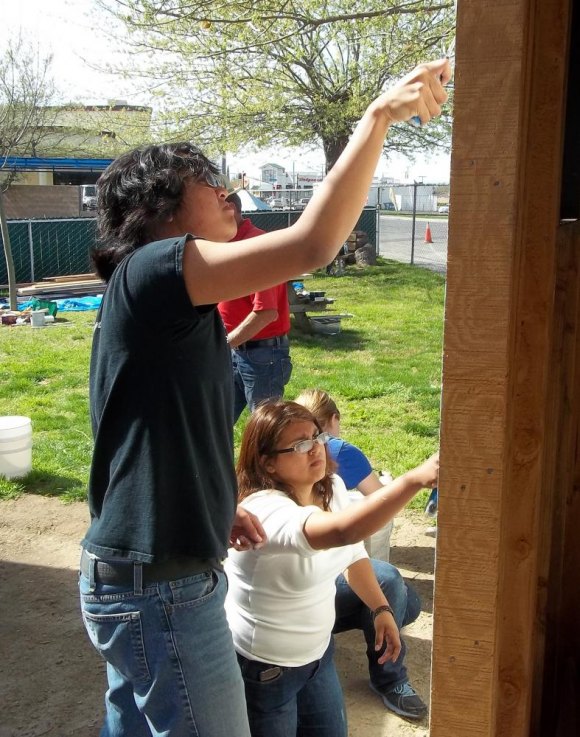 Middle College High School students Joseph Cruz and Brenda Gutierrez apply a coat of paint to Generations, a facility for seniors in Lemoore.