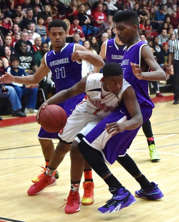 Jerald Campbell and Jaylunn English surround a Hanford player