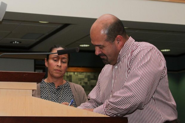 Newly elected councilmember, Ray Madrigal signs his papers after his swearing in.