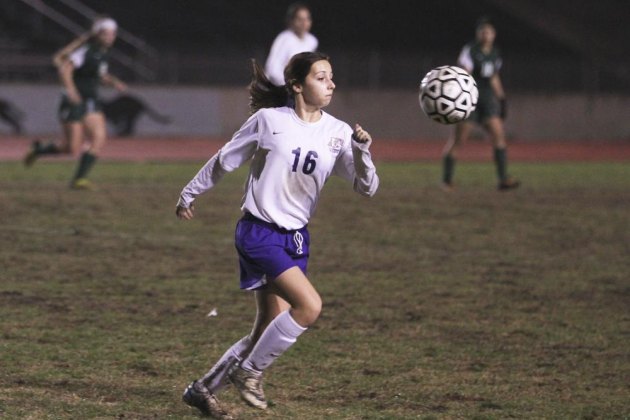 Freshman Michaela Ramirez runs in the mud of Tiger Stadium in win over El Diamante.