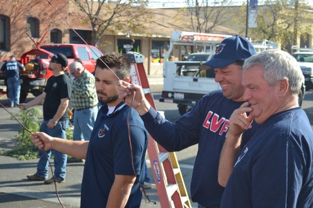 Lemoore Volunteer Fire Department puts on show as firemen raise annual Christmas tree Volunteer Firemen hold the lines as the annual tree goes up in downtown Lemoore