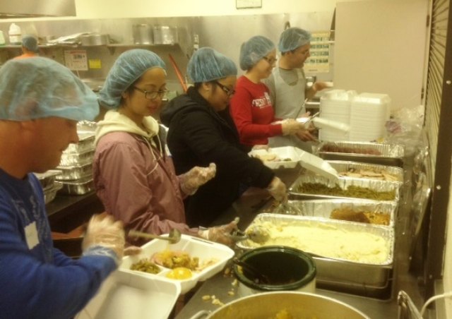 volunteers prepare meals at Community Thanksgiving dinner on Thursday.